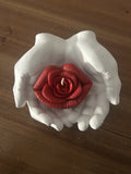 main qui tient bouche en rose